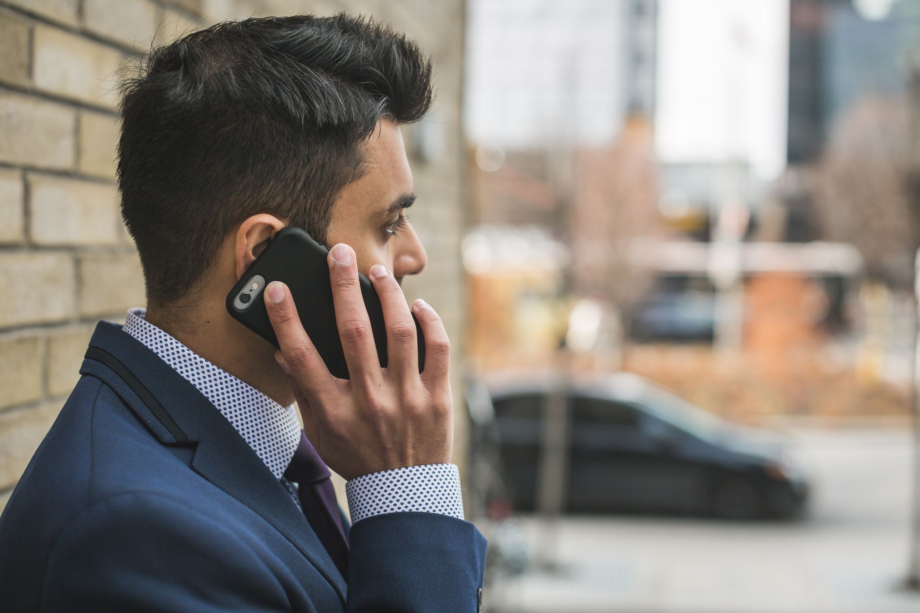 Professional man in suit making a phone call outside in city setting. — Dr Valinda Nwadike - Dedicated to Transforming Lives