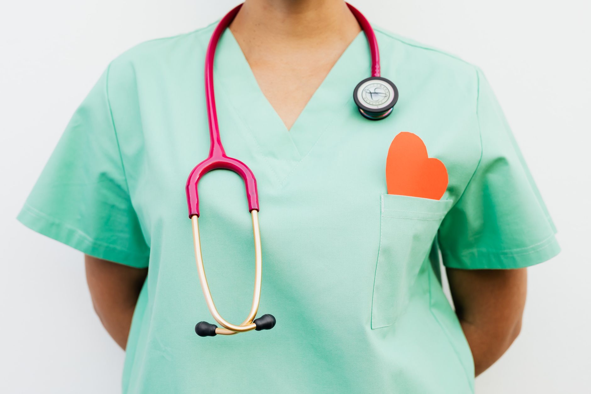 Close-up of a medical professional with a stethoscope and a paper heart cutout on a green uniform pocket. — How Dr. Steven Mu