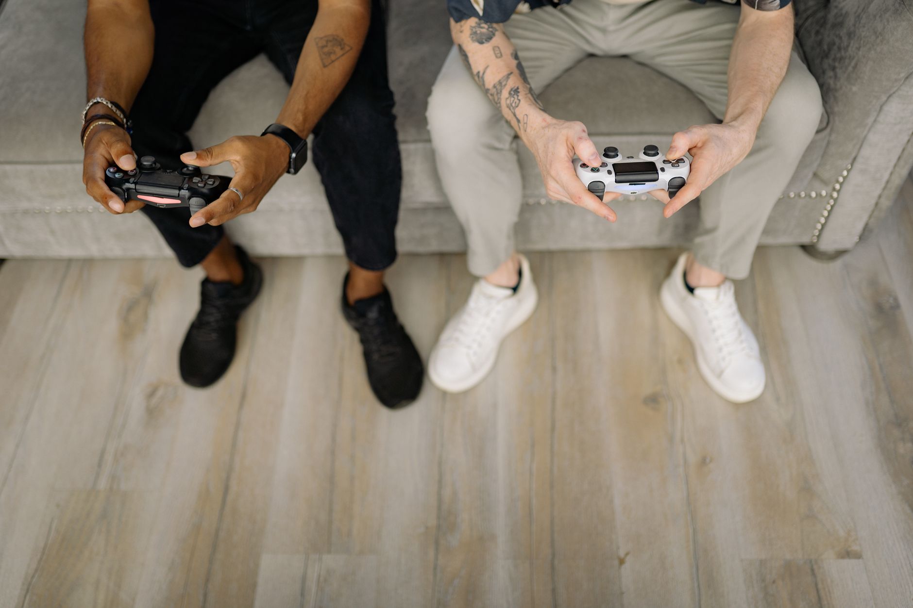 Two friends with gaming controllers focusing on a video game indoors from above. — Play Anytime, Anywhere with a Direct Slots