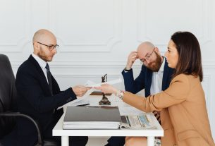 Professional meeting with lawyer and clients discussing documents in a modern office. — Policy Limit Tracing Ensures Complete