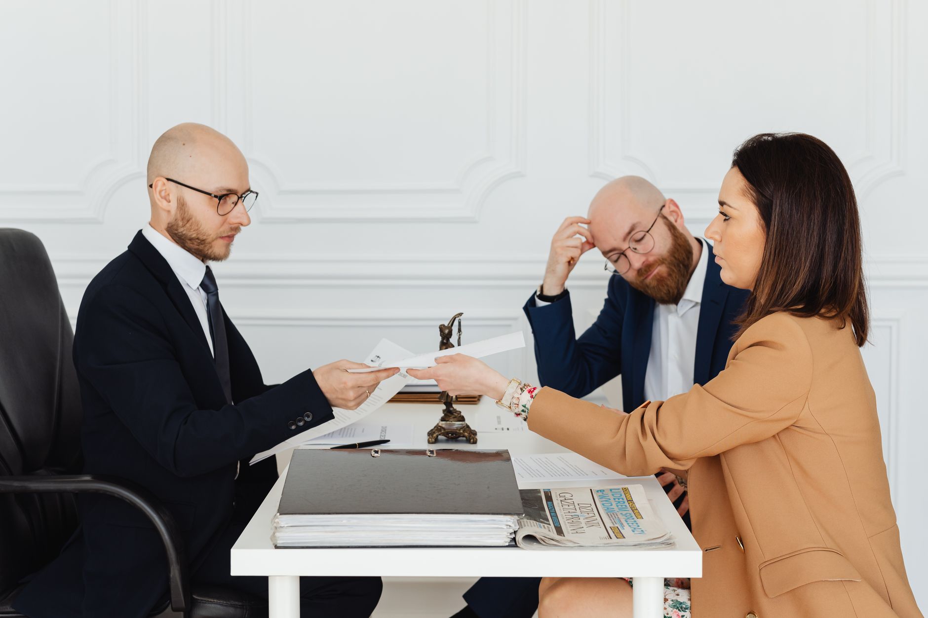 Professional meeting with lawyer and clients discussing documents in a modern office. — Policy Limit Tracing Ensures Complete