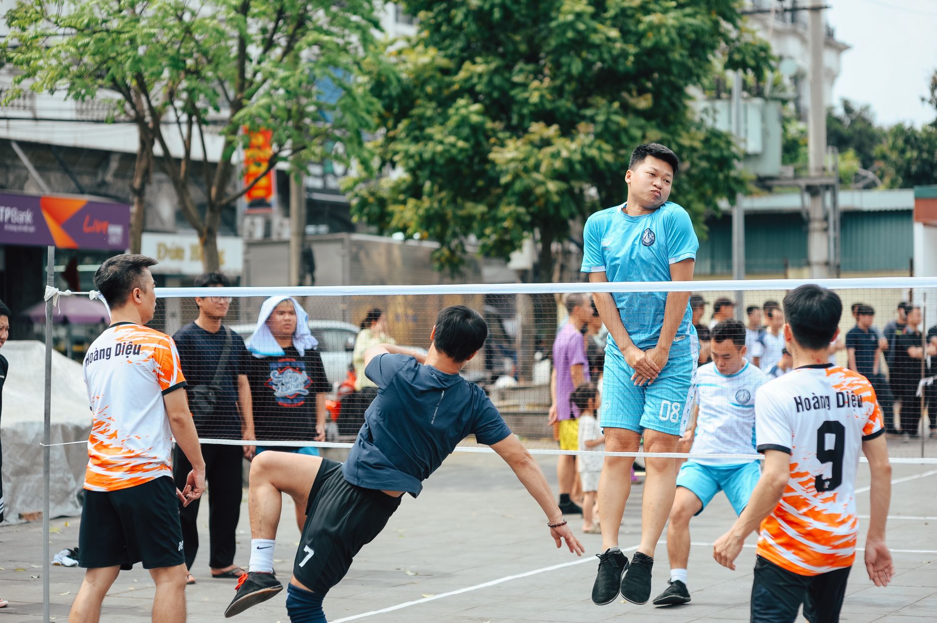 Dynamic foot volleyball game with six adults actively playing in a lively outdoor park scene. — What to Know Before Purchasin