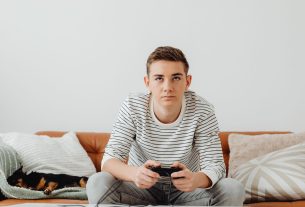 Teen boy intensely focused on video games at home, relaxing on a couch. — Why Mpo007 Offers Excellent Customer Support for a