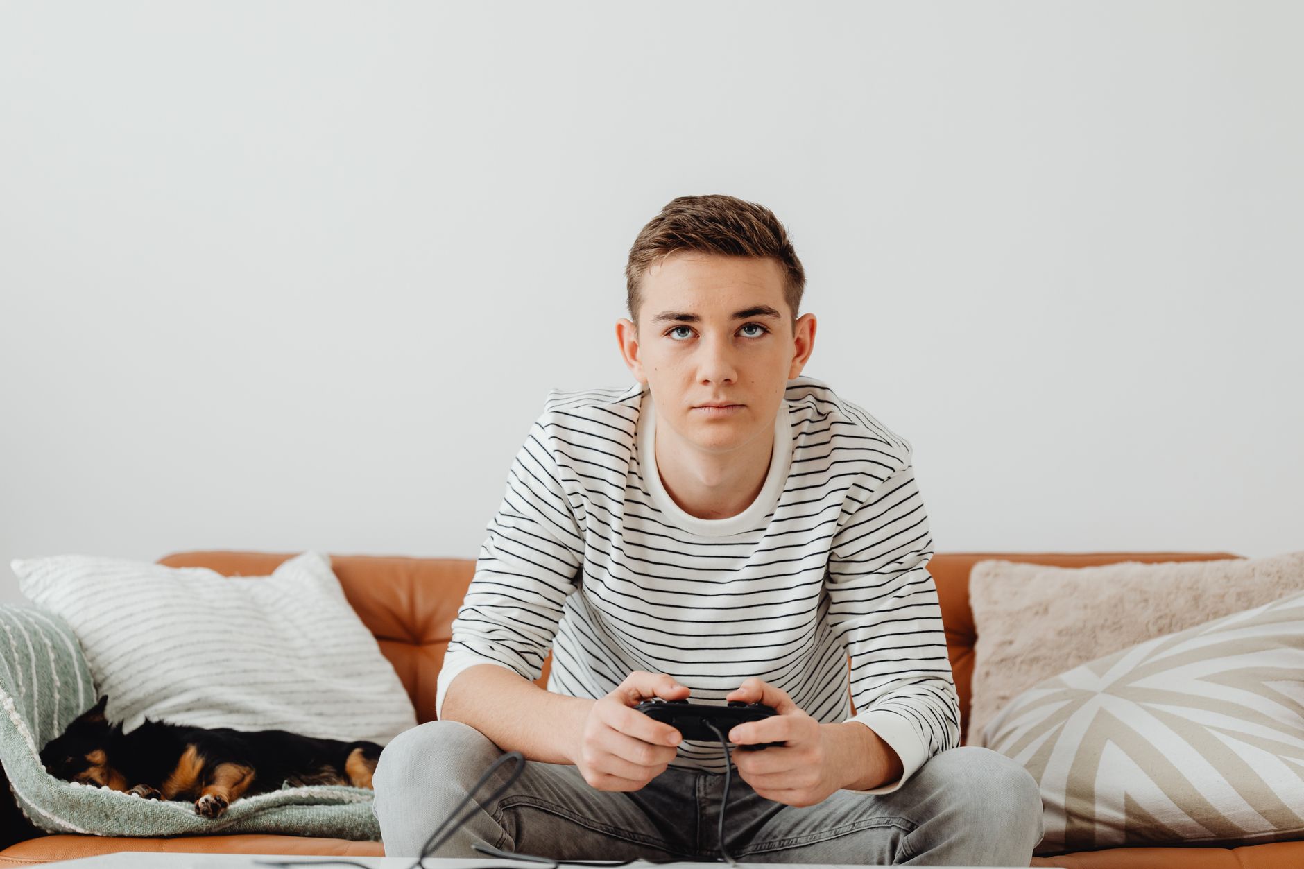 Teen boy intensely focused on video games at home, relaxing on a couch. — Why Mpo007 Offers Excellent Customer Support for a